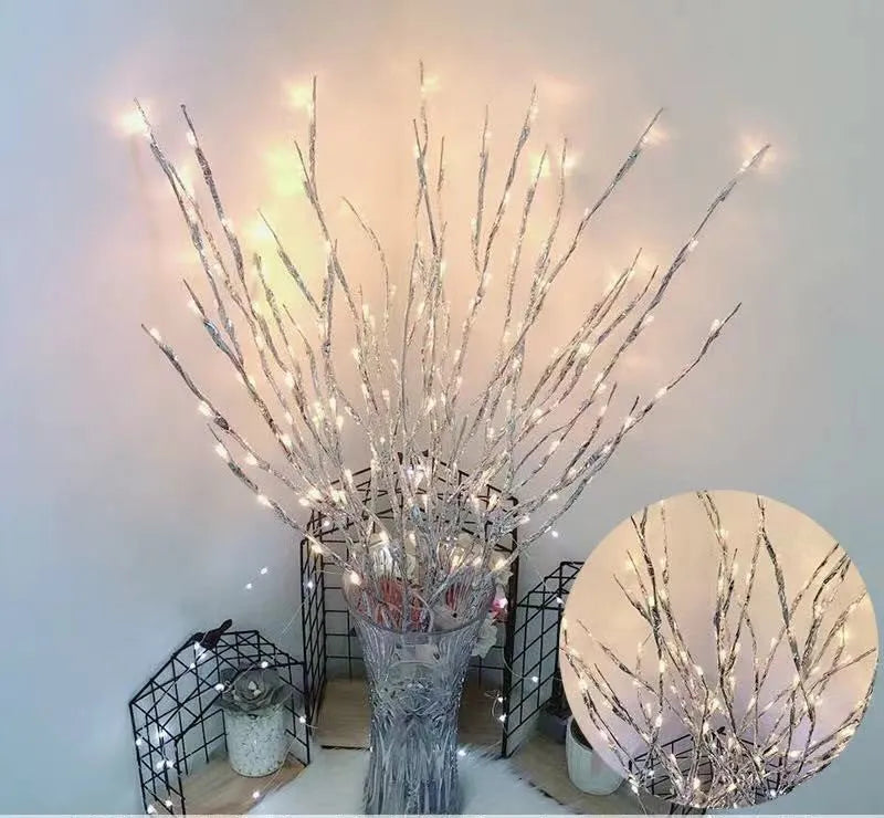 LED decorative tree light with coloured illumination in a vase, showing silver branches.