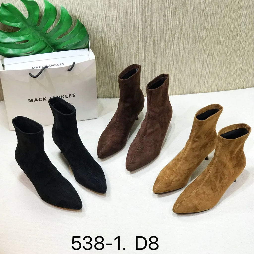 Black pointed toe women's ankle boots with stiletto heel on a plain background