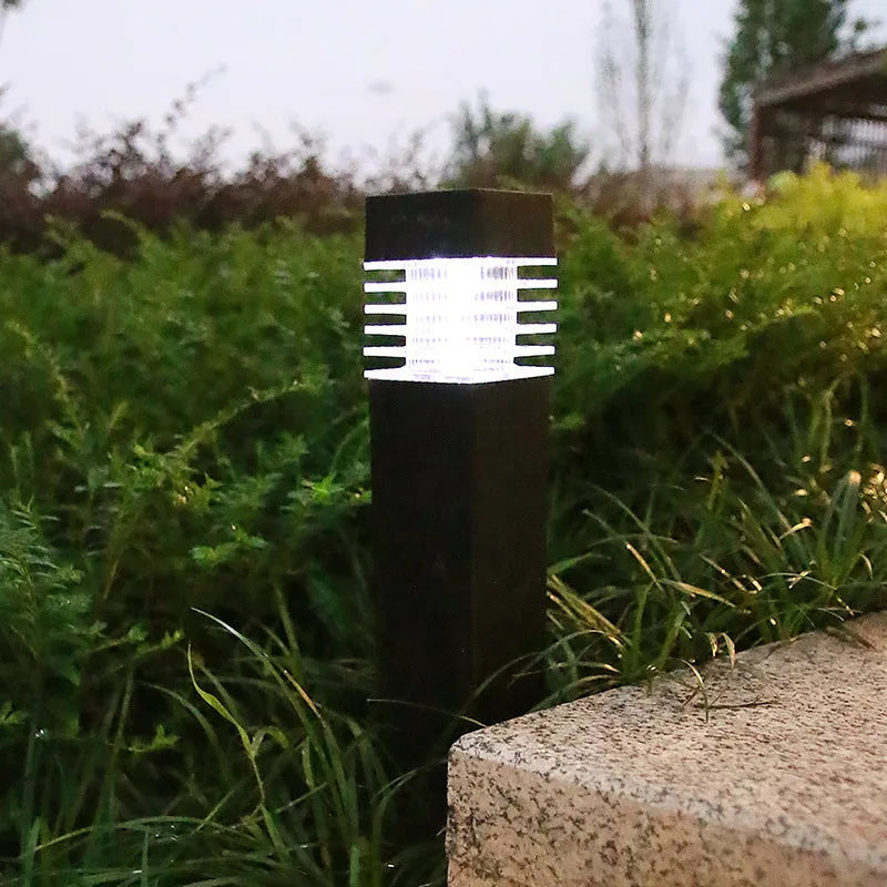 White cuboid solar-powered ground lamp for garden and pathway lighting.