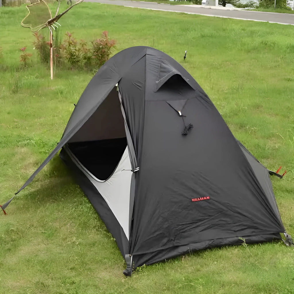 Single person orange hiking tent with aluminium poles pitched in outdoor setting