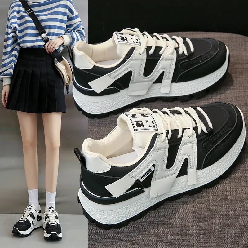 Pair of low-top unisex casual sneakers in black or white with round toe and front lace-up closure.