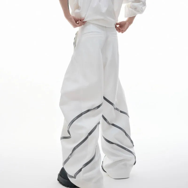 Men's black trousers with silver metal striped rivet details and pleated front.