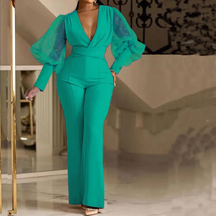 Red women's jumpsuit with mesh-stitch long sleeves, elastic waist, and wide-leg trousers on a model.