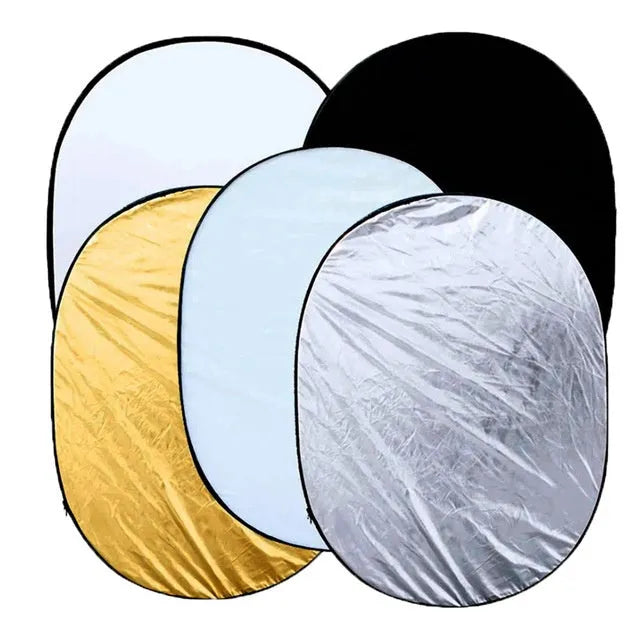 A large, rectangular collapsible photography light reflector showing its five different coloured surfaces: gold, silver, white, black, and translucent.