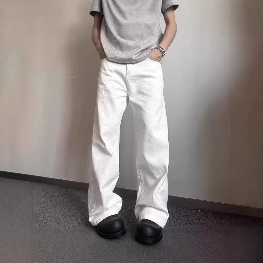 Men's white straight-leg denim jeans on a neutral background, showing mid waist and loose fit.