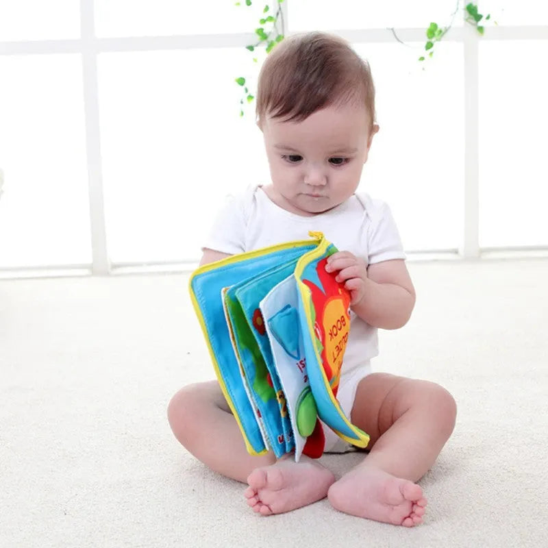 Multi-functional soft cloth baby book with zip and carry handle, 18.5cm wide by 20cm high, 12 pages.