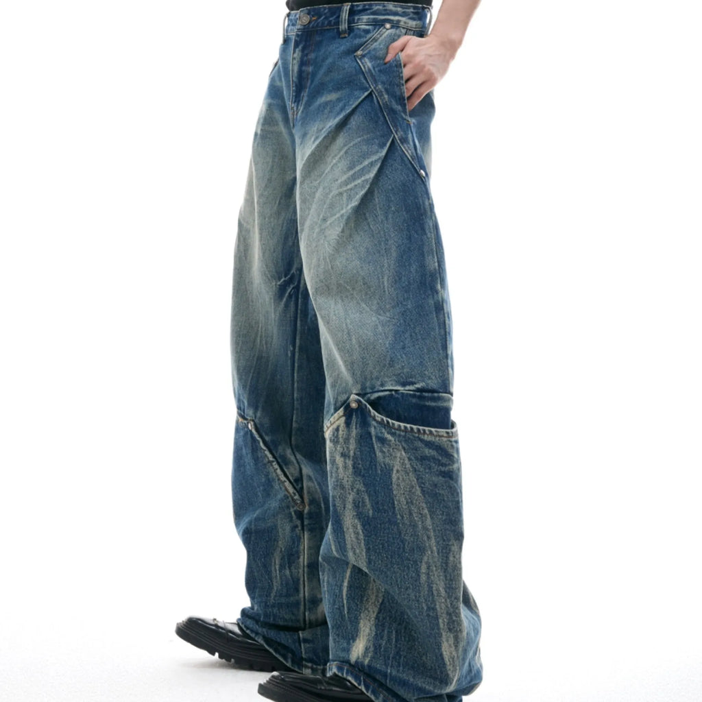 Man wearing verdant blue retro washed burst pattern jeans with a curved knife cut and loose fit.