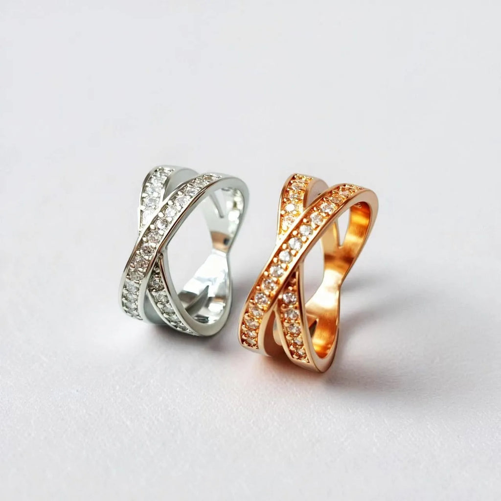 Geometric silver cross ring with micro-inlaid zircon stones on a model's finger.