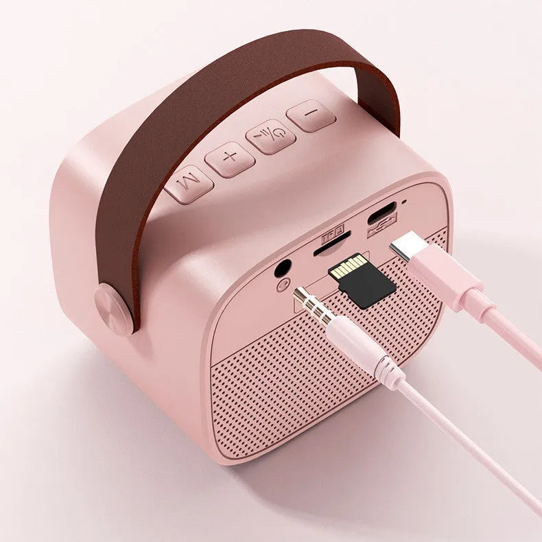 Small white portable Bluetooth speaker with built-in microphone on a table.