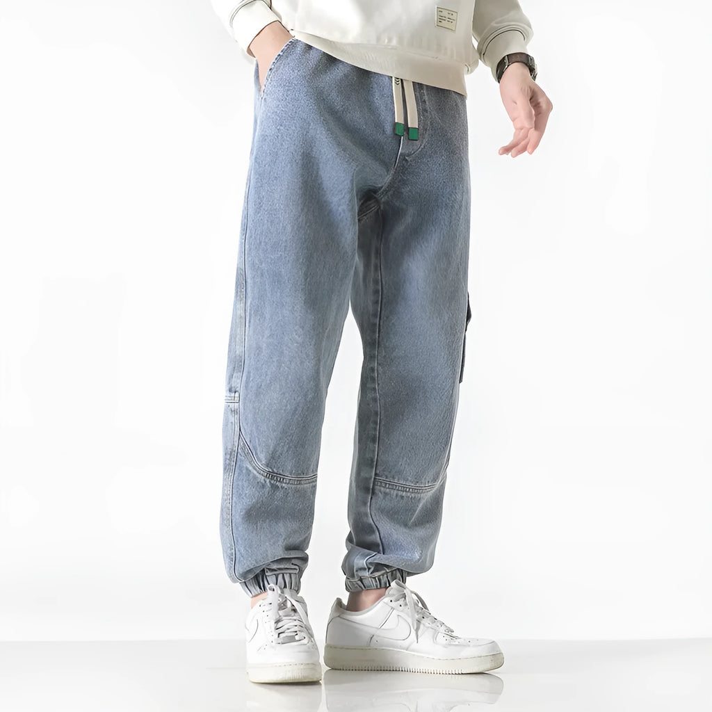 Men's loose-fit tapered cotton trousers in black, shown on a model
