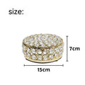 Transparent crystal glass jewelry box with a French gold metal frame on a table.