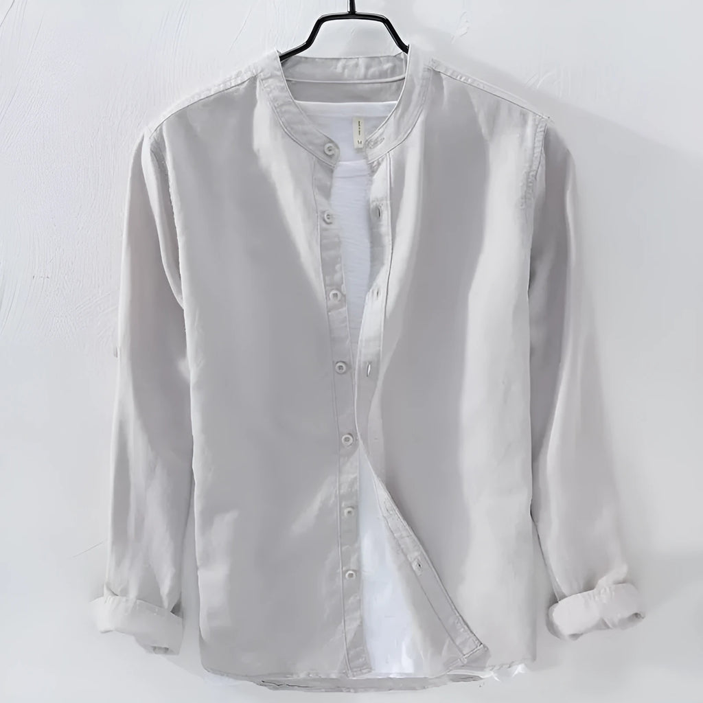 Man's loose fitting long sleeve linen shirt in a solid colour on a hanger.