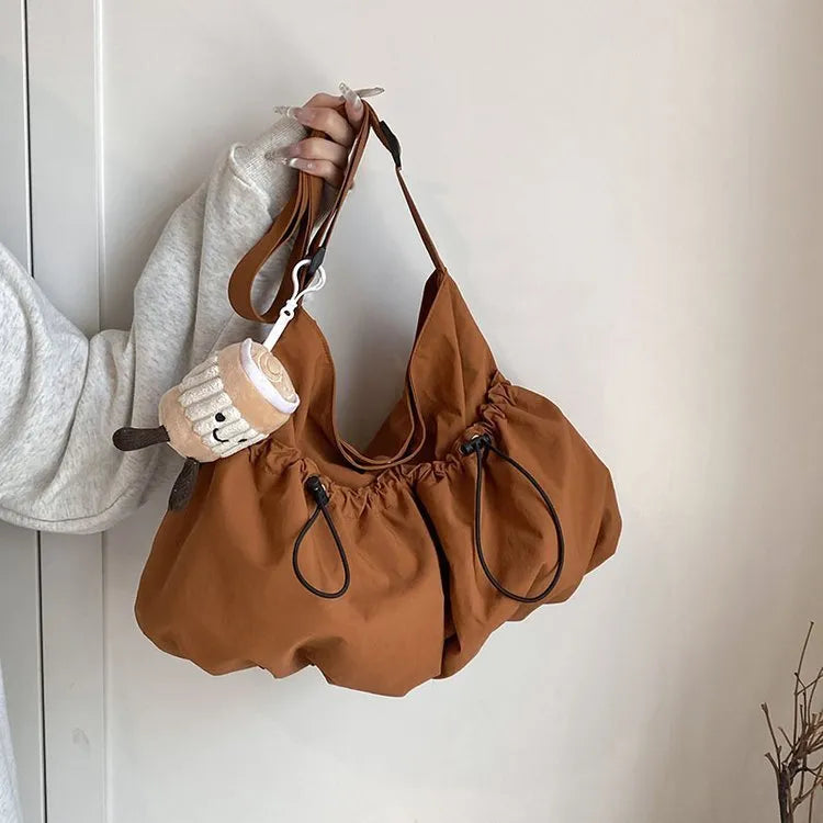 Green ultra-light pleated crossbody bag showing split pocket design and compact 35cm dimensions