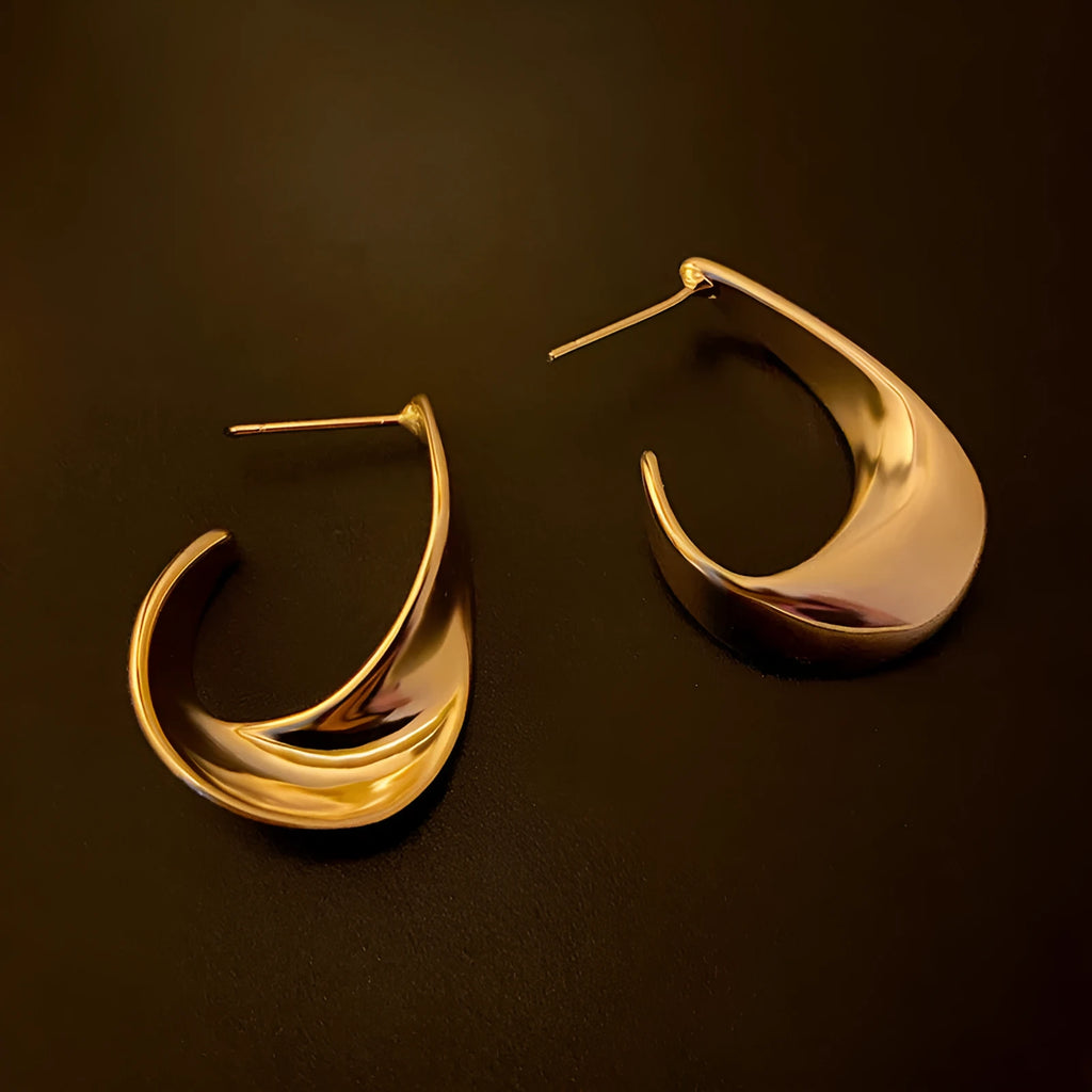 Metal twisted geometric earrings with round elements in gold or silver finish