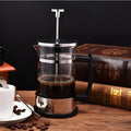 Glass manual coffee maker with stainless steel filter, 350ml capacity, dimensions 10cm by 8cm by 17cm.