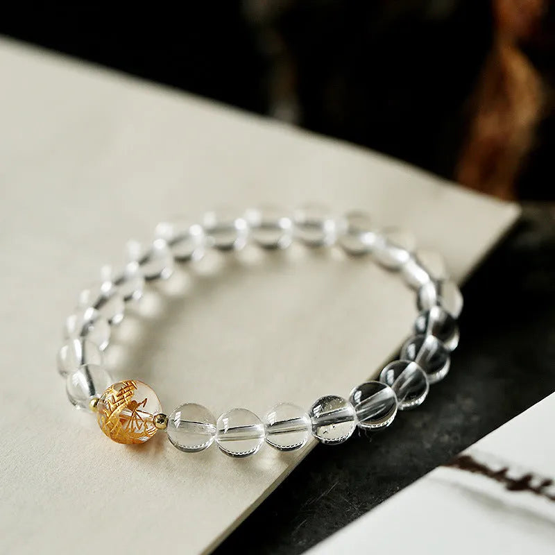 Unisex geometric bracelet with black obsidian, white crystal beads, and a golden dragon bead on a wrist.
