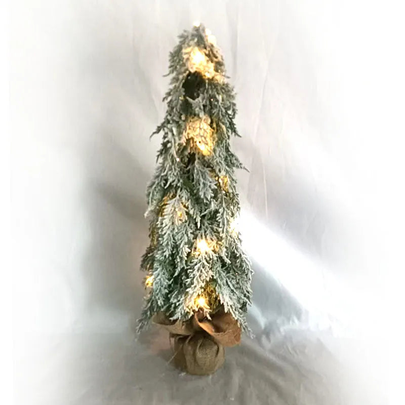 24-inch artificial Christmas tree with snow spray finish and integrated lights on desktop