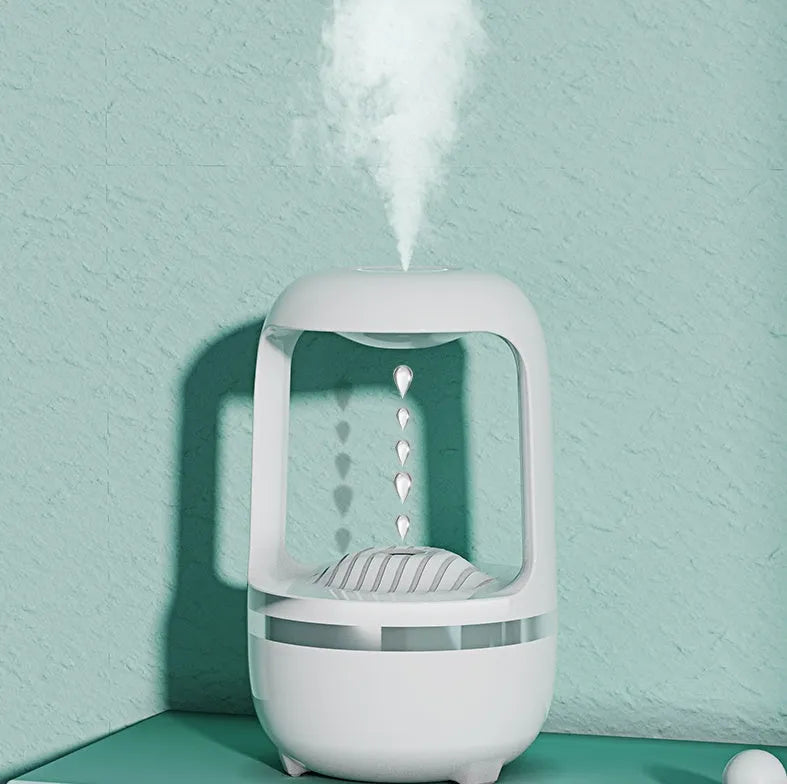 White anti-gravity humidifier with upward-flowing water droplets on a desk