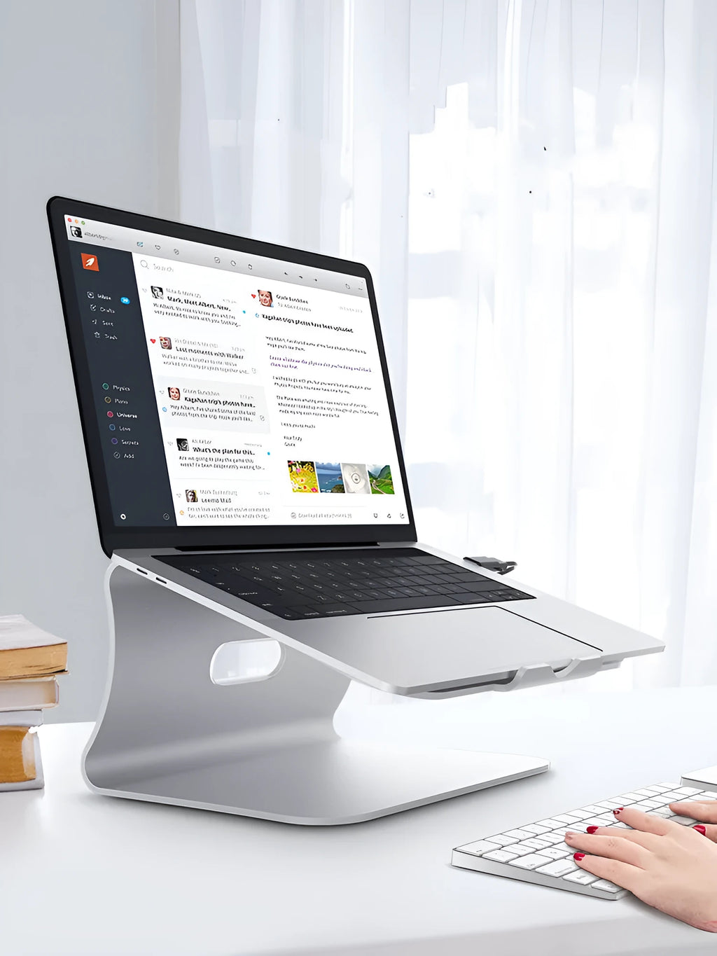 Aluminium alloy laptop cooling bracket in grey colour with rotary hinge adjustment on a desk.