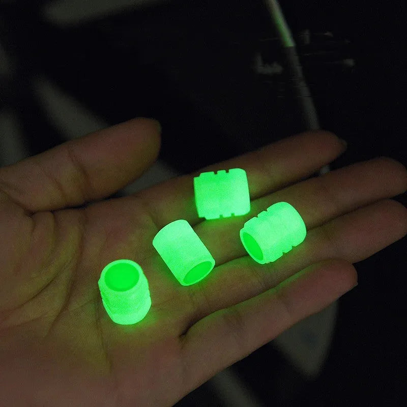 Pack of four black rubber car valve caps with luminous glow-in-the-dark tops.