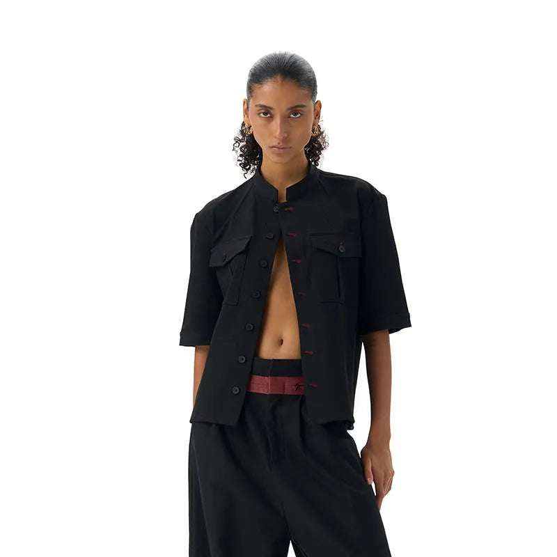 Black handmade Red Eye half sleeve hunting shirt with a shirt collar on a hanger.