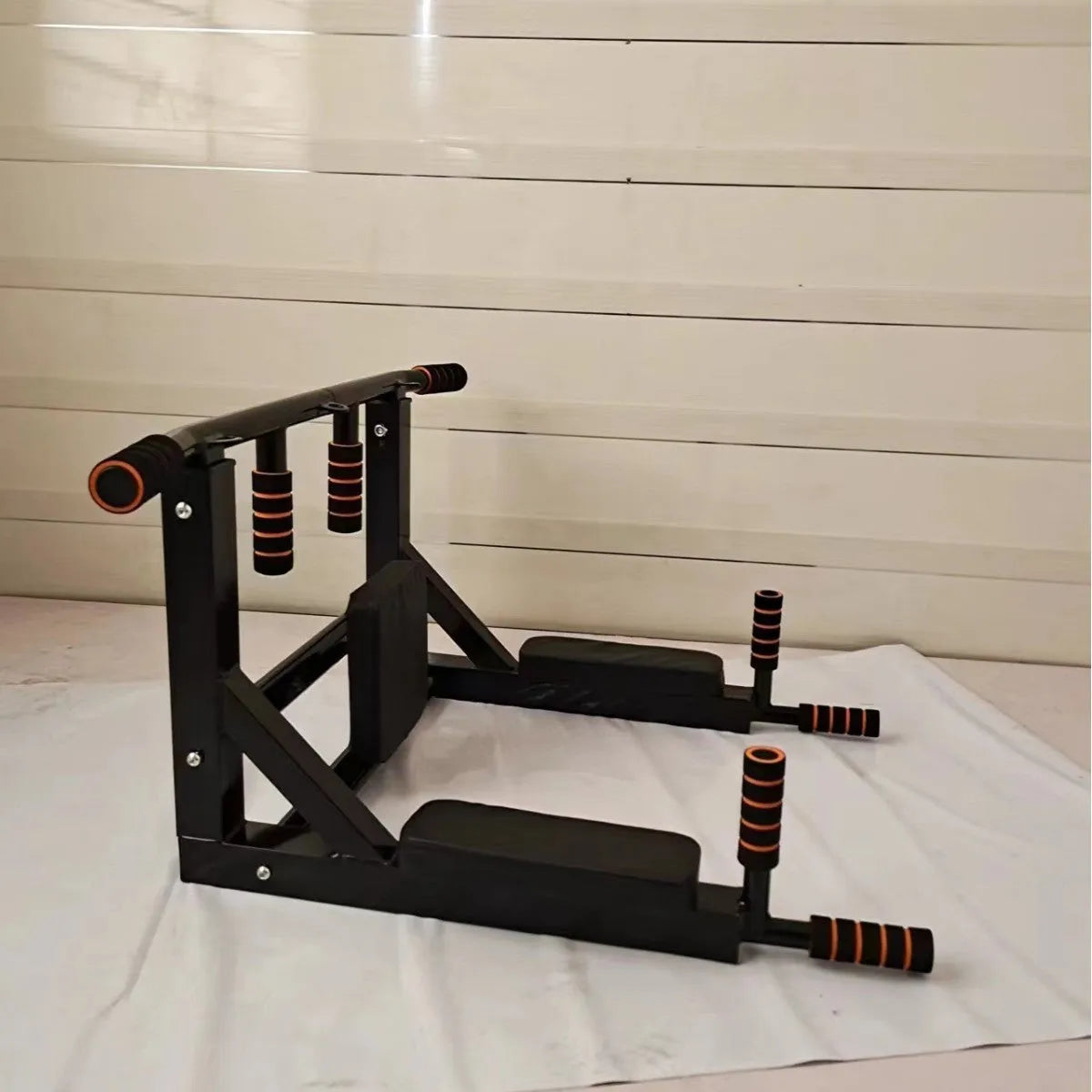Black wall-mounted metal sandbag rack with integrated pull-up bars for fitness training