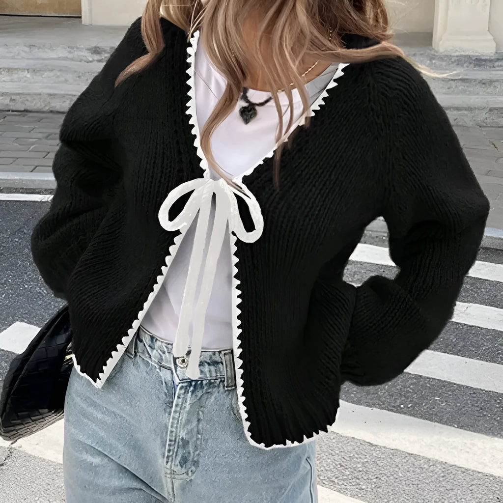 Grey lace-up front cardigan with crocheted flower detail on sleeve, shown loose and open.