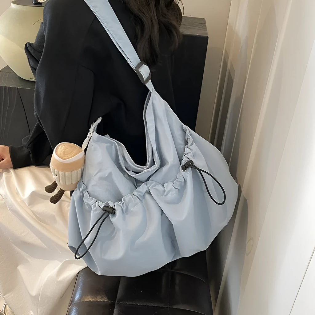 Green ultra-light pleated crossbody bag showing split pocket design and compact 35cm dimensions