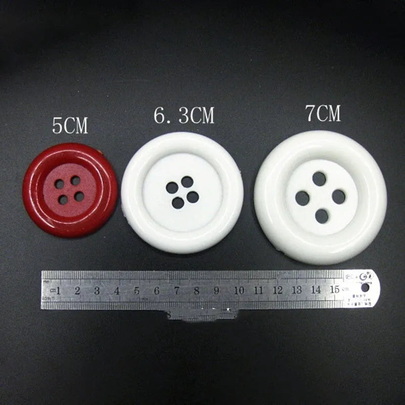 Assortment of large round plastic sewing buttons in multiple colours with four holes.