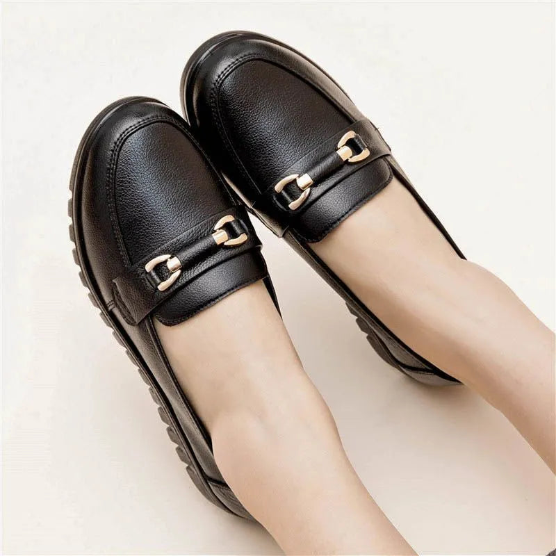 Black soft leather women's pumps with a round toe, low flat heel, and rubber sole.