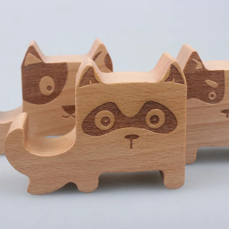 Solid beech wood mobile phone stand with a decorative resin animal ornament and a coin slot.
