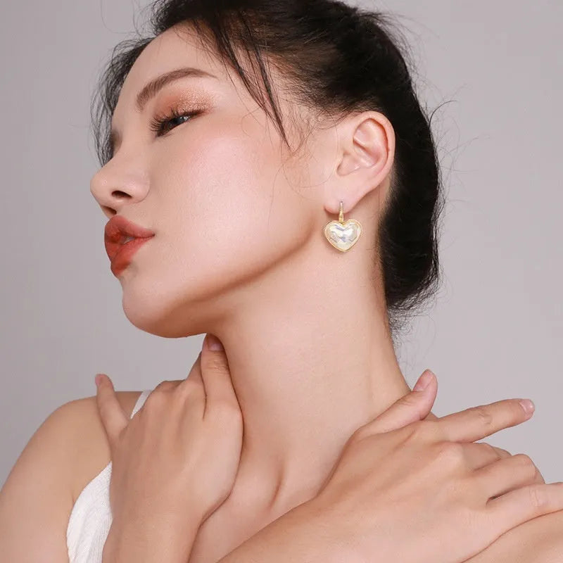 A pair of gold-coloured women's ear clips with a natural design on a white background.