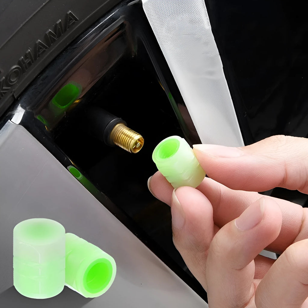 Pack of four black rubber car valve caps with luminous glow-in-the-dark tops.