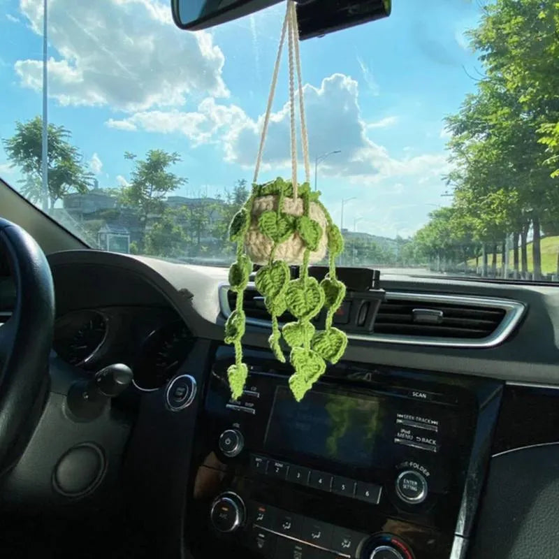 Green and white knitted wool car plant decoration basket with white hanging cord.