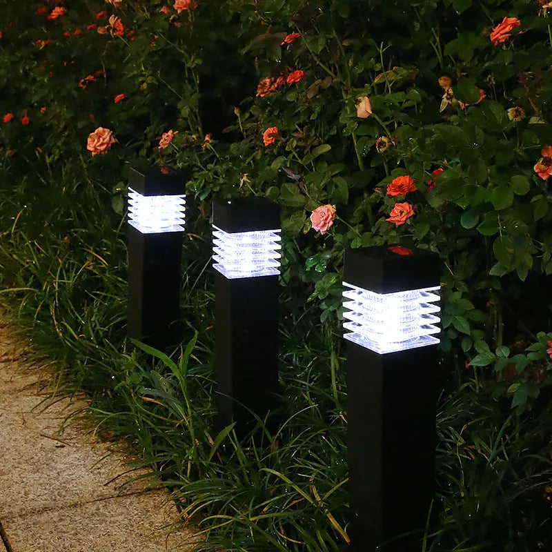 White cuboid solar-powered ground lamp for garden and pathway lighting.