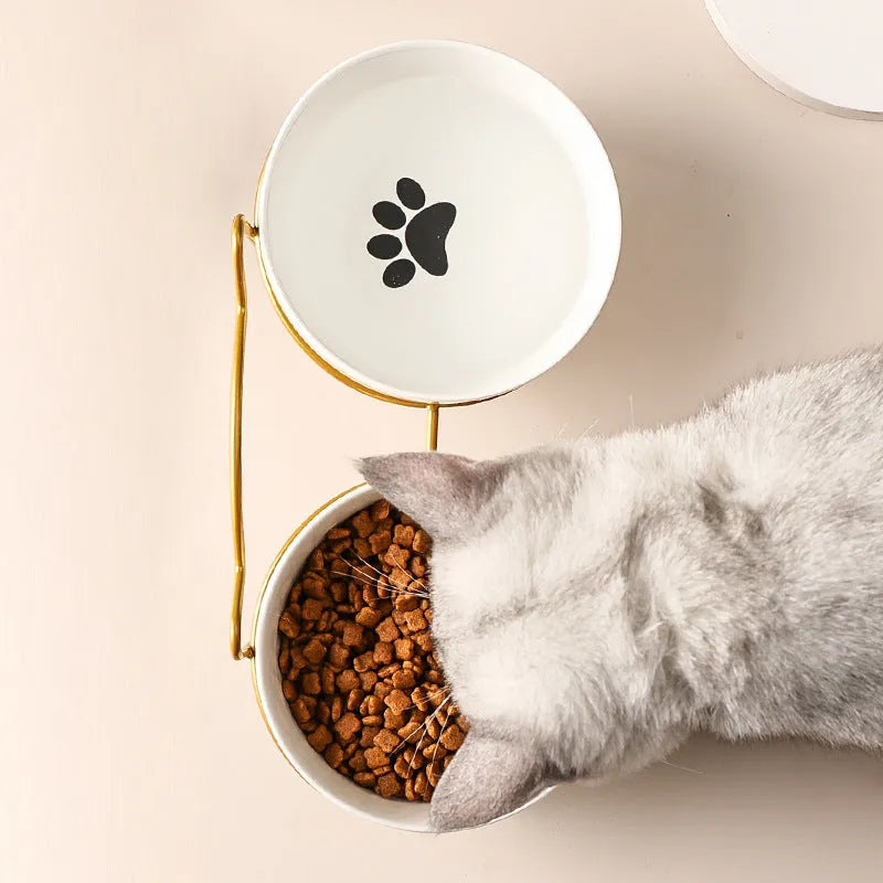 White ceramic cat bowl with decorative iron frame in cat footprints pattern