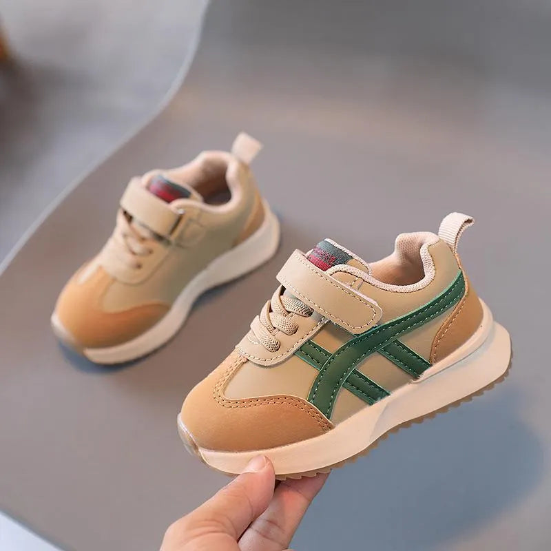 Children's white synthetic leather sneakers with Velcro strap and rubber sole.