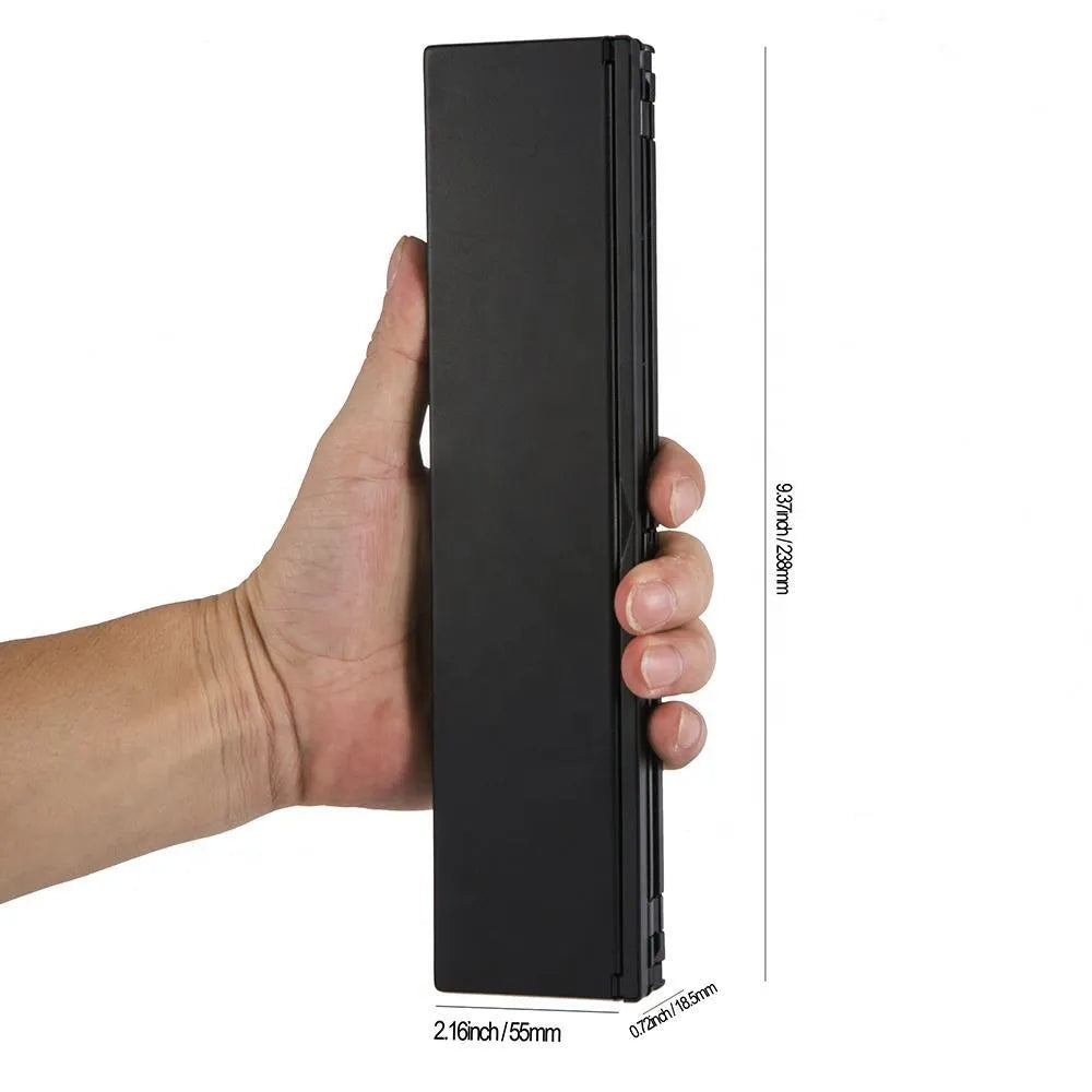 Black folding Bluetooth keyboard unfolded next to tablet showing ultra-thin design