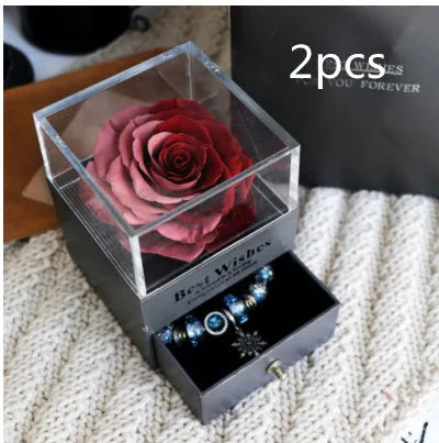 Glass eternal flower jewellery box with preserved roses and carnations inside measuring 8.5cm square