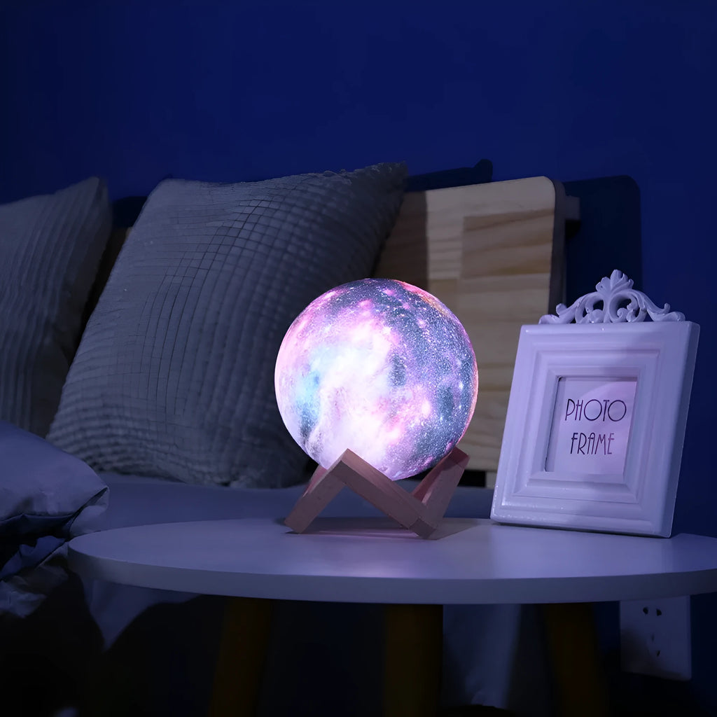White spherical lunar night light with textured surface and soft LED glow on a dark surface.
