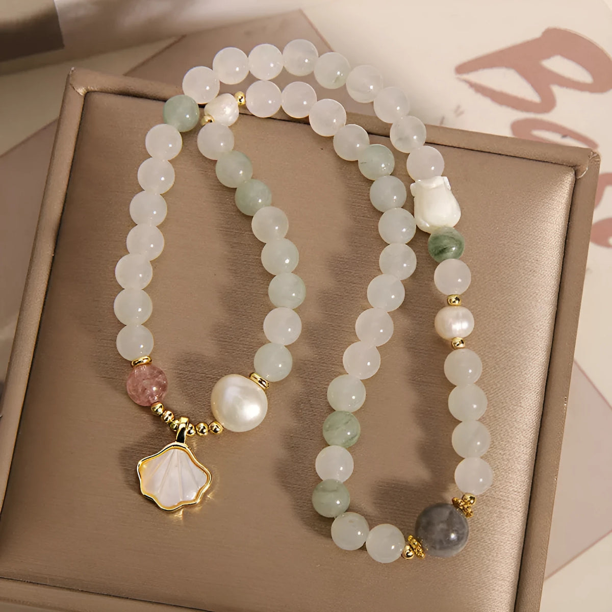 Emerald green crystal bracelet with ginkgo leaf pendant and gold-plated rhinestone details