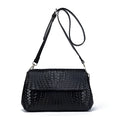 Black genuine leather woven crossbody bag with embossed finish, soft carry handle, and single shoulder strap.