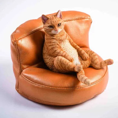 Small resin ornament of a cat sleeping on a sofa for car dashboard or shelf decoration.