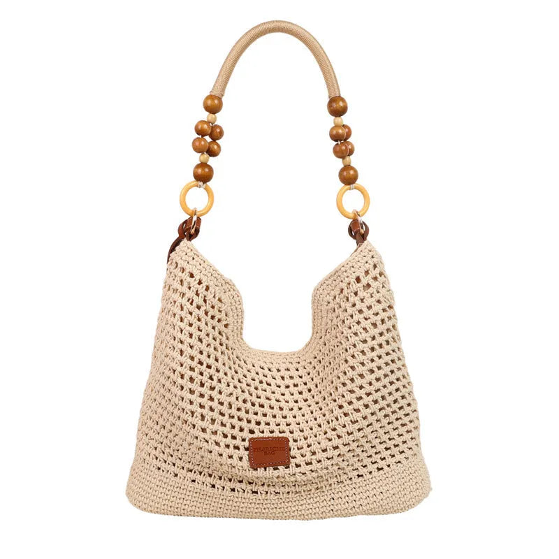Knitted beach tote bag with crossbody strap showing stitching details and bucket shape