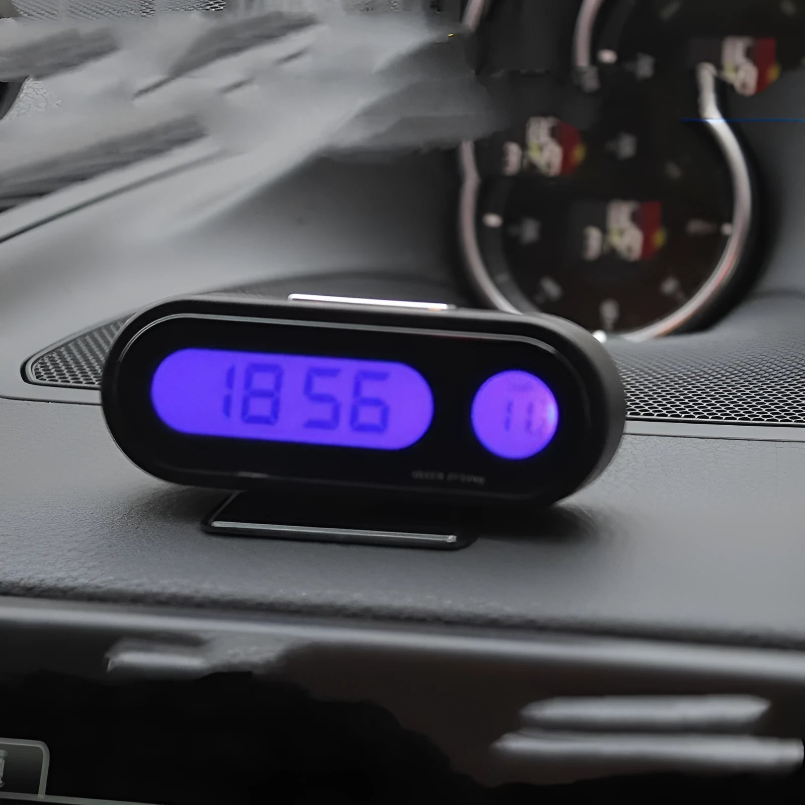 Black electronic car clock thermometer with digital LED display showing time and temperature, featuring an adjustable base.