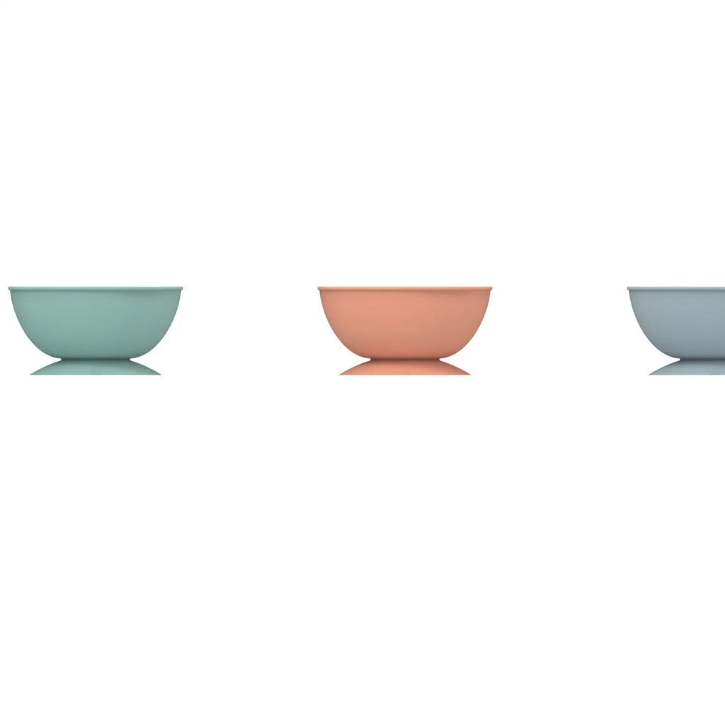 Cyan silicone dog bowl with licking mat texture and suction cup base on a hard floor