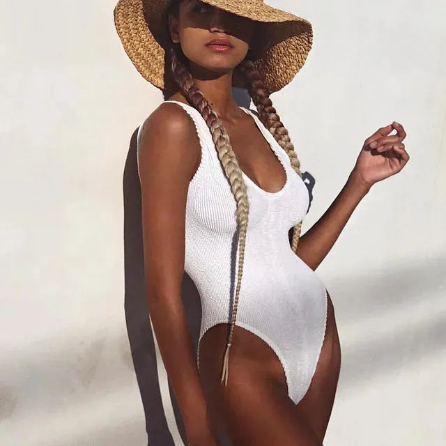 Women's solid colour seersucker one-piece swimsuit on a hanger, showing backless design.