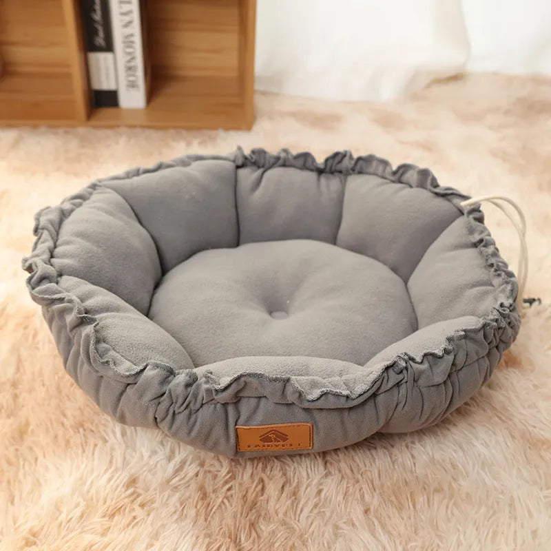 Grey reversible donut-shaped pet bed for cats and small dogs on a wooden floor.