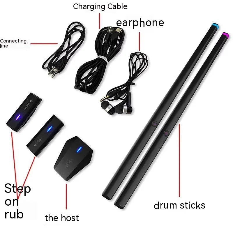 Black somatosensory air drum kit main unit with LED lights, two drumsticks, and a floor sensor on a table.