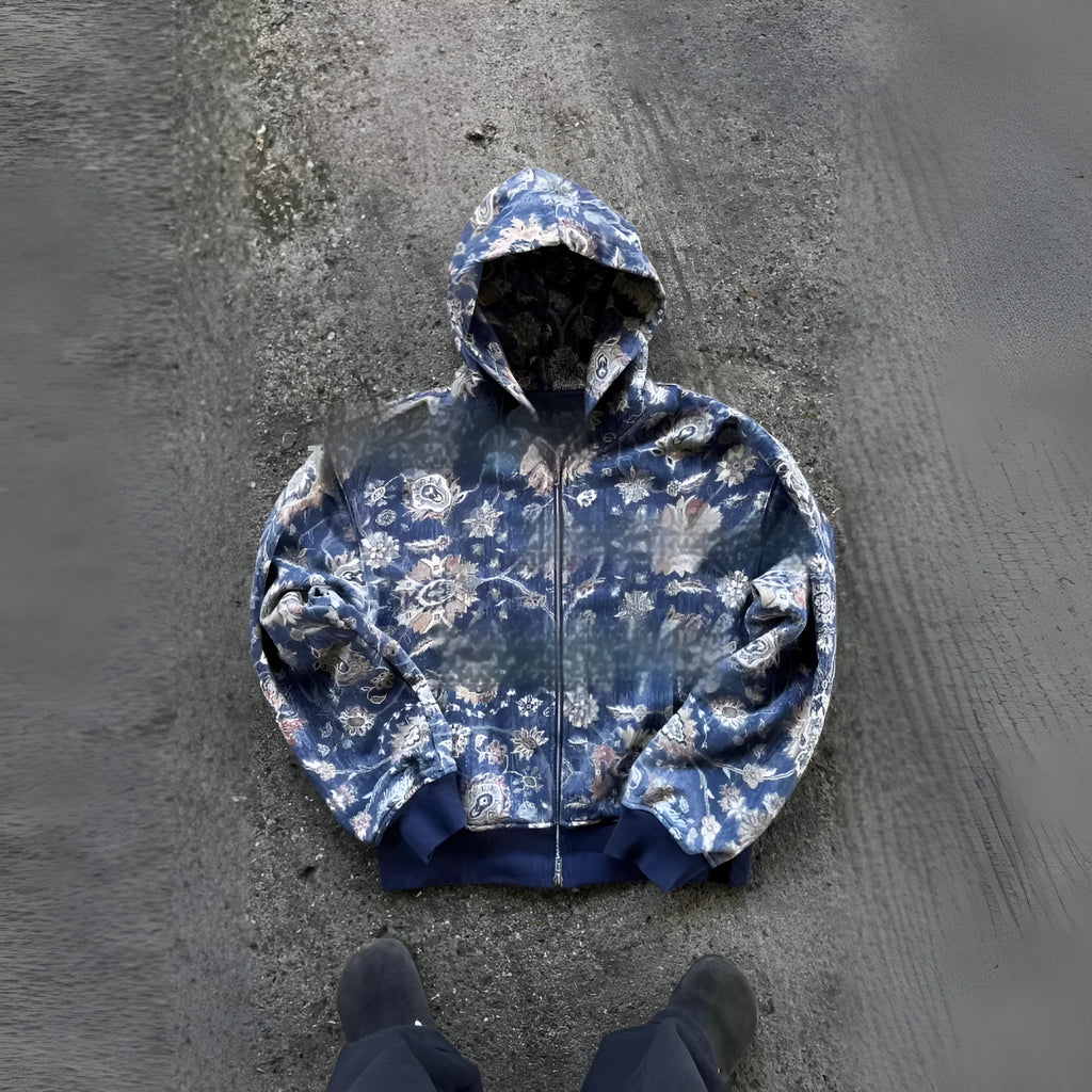 A man's loose-fitting zip-up hooded coat in red or blue with a digital print design.